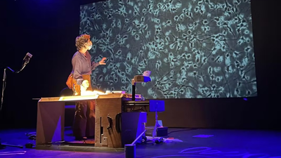 Une femme à une marionnette d'enfant des organismes végétaux sur un écran.