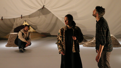 Deux comédiens et une comédienne dans un décor de grotte.